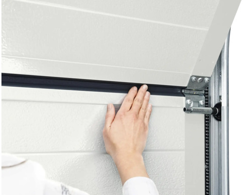 Détail d'une porte de garage avec main, joint et ferrures