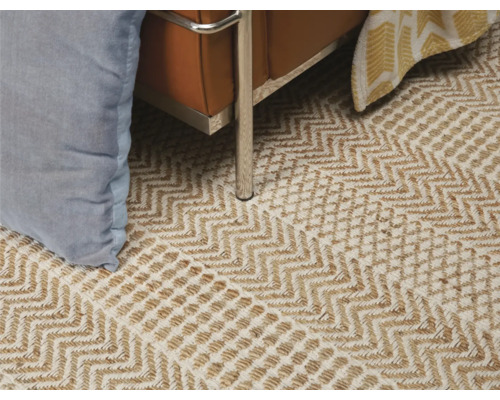 Gros plan d''un tapis à motif en zigzag sous un canapé