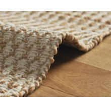 Vue détaillée d''un tapis tressé en fibres naturelles sur un plancher en bois