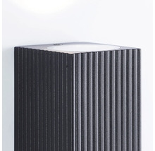 Lavabo foncé avec surface rainurée sur un mur blanc