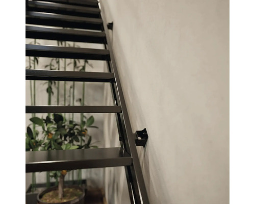 Detailaufnahme einer schwarzen Stahltreppe an einer Wand