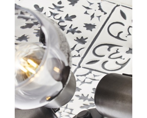 Nahaufnahme einer Wandleuchte vor gemusterten Fliesen