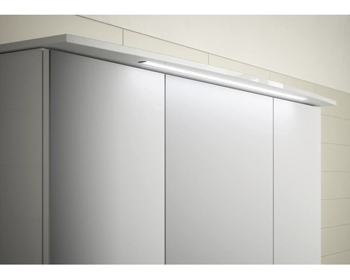 Lineare LED-Aufsatzleuchte für einen Spiegelschrank im Badezimmer zur Montage auf dem Schrankdeckel.