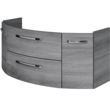 Gebogener Waschbeckenunterschrank in grauer Holzoptik mit drei Schubladen und silbernen Metallgriffen.