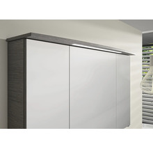 Kleiderschrank mit weissen Fronten, dunklem Korpus in Holzoptik und integrierter LED-Aufsatzleuchte am Kranz.