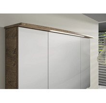 Kleiderschrank mit weissen Fronten, Korpus in dunkler Holzoptik und integrierter LED-Beleuchtung am Oberboden.