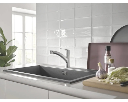 Scène de cuisine avec évier, robinet et aliments sur un plan de travail.