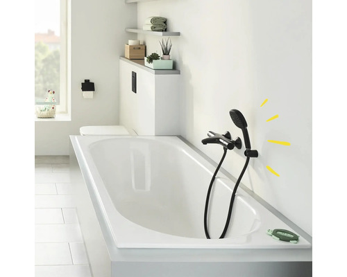 Badezimmer mit Badewanne, schwarzer Armatur und Ablageflächen