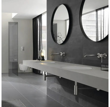 Salle de bains moderne avec lavabo, miroirs ronds et carreaux foncés