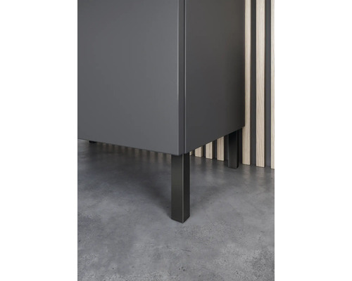 Detailansicht eines grauen Badezimmerschranks mit schwarzen Füssen.