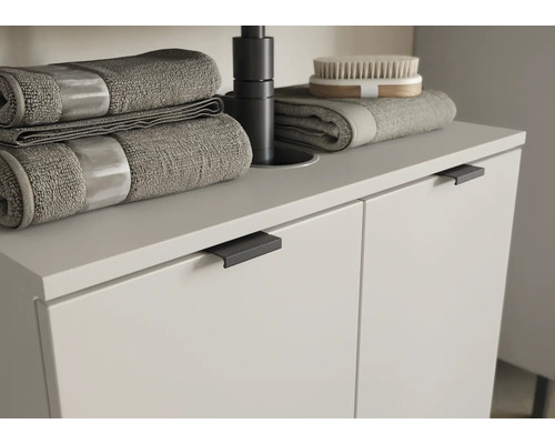 Meuble sous-lavabo avec serviettes et brosse dans la salle de bain