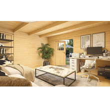 Petite maison en bois claire avec espace de vie et poste de travail, comprenant un canapé, une table et du mobilier de bureau.