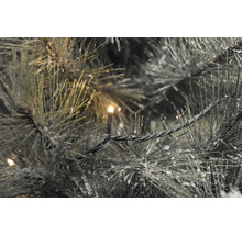 Gros plan d''une guirlande de sapin artificielle illuminée avec de la neige