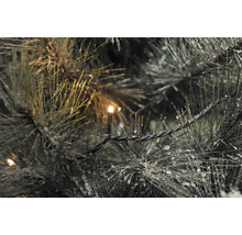 Gros plan d''un sapin artificiel illuminé avec de la neige