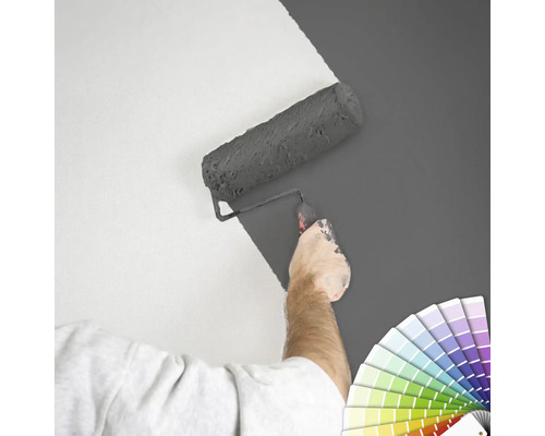 "Eine Person streicht eine Wand mit einer Farbwalze
