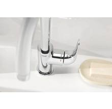 Logo Grohe. Mitigeur monocommande en métal sur le lavabo.