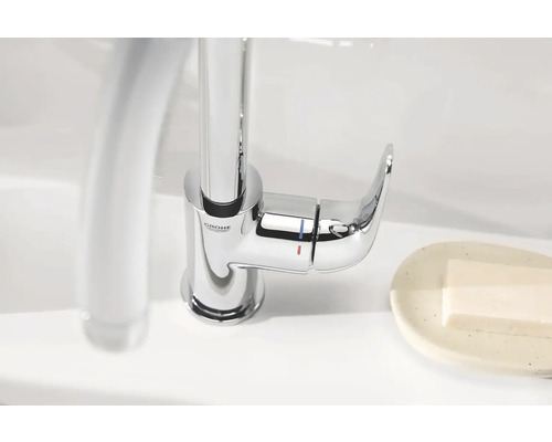 Logo Grohe. Mitigeur monocommande en métal sur le lavabo.