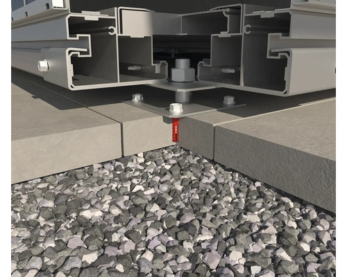 Gros plan d''une construction métallique, fixée par des vis sur des pavés de béton, entourée de gravier.