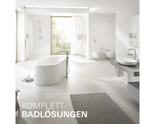 Helles Badezimmer mit Badewanne, Dusche, Waschbecken, Toilette und Bidet.