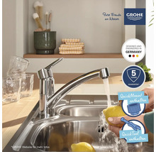 Küchenspüle mit Wasserhahn und einer Person, die eine Zitrone wäscht. Grohe Logo. Fünf Jahre Garantie. Entwickelt und hergestellt in Deutschland.