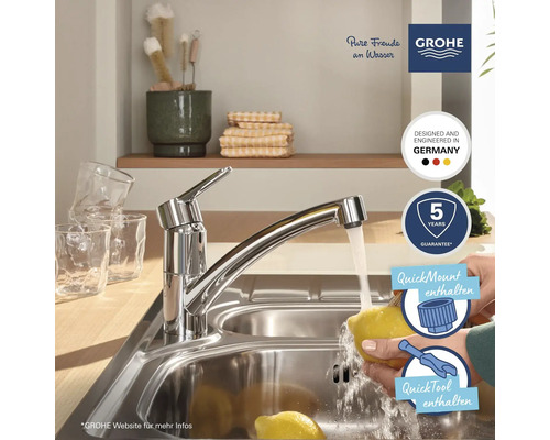 Küchenspüle mit Wasserhahn und einer Person, die eine Zitrone wäscht. Grohe Logo. Fünf Jahre Garantie. Entwickelt und hergestellt in Deutschland.