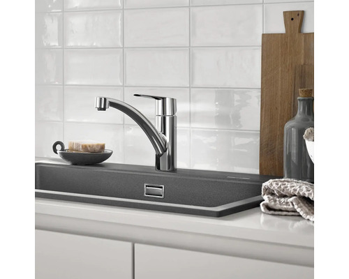 Scène de cuisine avec robinet d''évier, évier et ustensiles de cuisine.