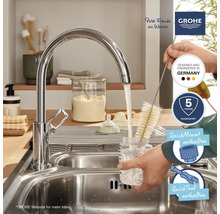 Scène de cuisine avec robinet Grohe, goupillon, évier et logos.