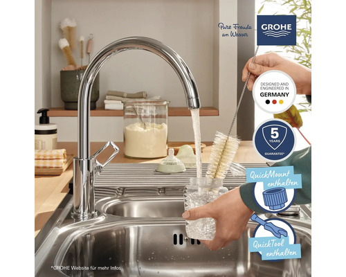 Scène de cuisine avec robinet Grohe, goupillon, évier et logos.
