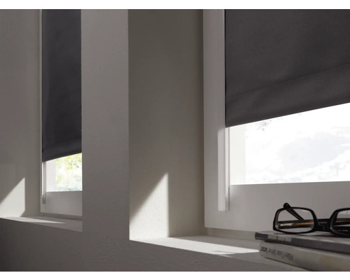Zwei Fenster mit heruntergelassenen Rollos in einem hellen Raum