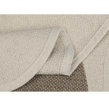 Detailansicht eines beigen Teppichs mit Bordüre