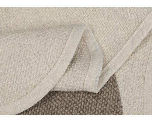 Detailansicht eines beigen Teppichs mit Bordüre