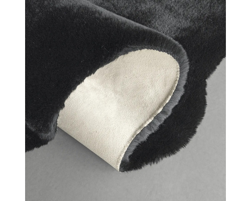 Schwarzer Teppich mit gewendeter Ecke zur Darstellung der Rückseite