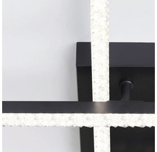 Gros plan d'une applique murale LED noire et moderne avec des éléments en forme de cristaux