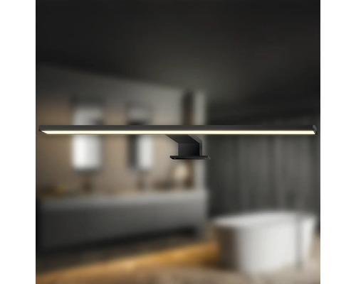 Badezimmer mit einer schwarzen LED-Wandleuchte über einem Waschbecken und einer Badewanne