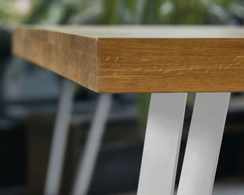 Detailansicht einer Tischplatte aus Holz mit Metallbeinen