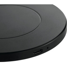 Nahaufnahme einer runden, schwarzen Ladestation mit USB-Anschluss.