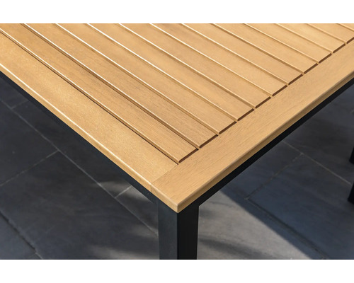 Vue détaillée d'un plateau de table de jardin en bois avec un piètement de table noir.