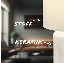 Nahaufnahme einer Lampe mit Lampenschirm aus Stoff und einem Lampenfuß aus Keramik