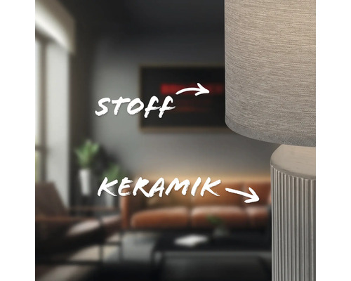 Detailaufnahme einer Lampe mit Stoffschirm und Keramikfuß in einem Wohnzimmer.