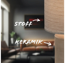 Nahaufnahme einer Lampe mit Stoffschirm und Keramikfuß in einem Wohnzimmer