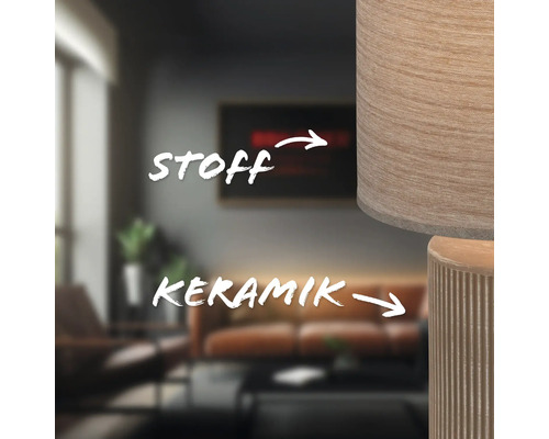 Nahaufnahme einer Lampe mit Stoffschirm und Keramikfuß in einem Wohnzimmer