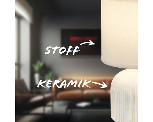 Nahaufnahme einer Tischleuchte mit Lampenschirm aus Stoff und Keramikfuß in einem Wohnzimmer.