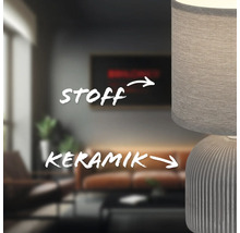 Nahaufnahme einer Tischleuchte mit Keramikfuß und Stoffschirm in einem Wohnzimmer