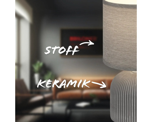 Nahaufnahme einer Tischleuchte mit Keramikfuß und Stoffschirm in einem Wohnzimmer