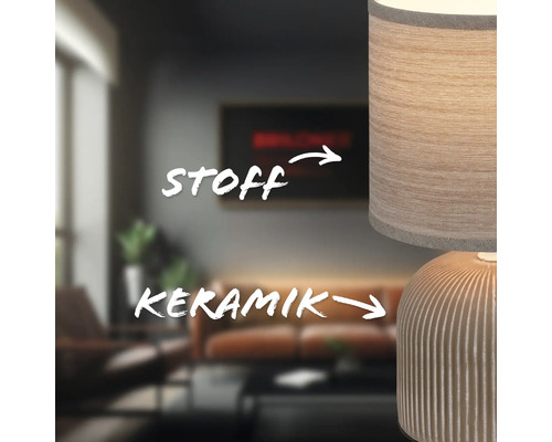 Nahaufnahme einer Tischleuchte mit Lampenschirm aus Stoff und Keramikfuß in einem Wohnzimmer.