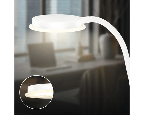Weisse Tischleuchte mit flexibler Halterung auf einem Schreibtisch