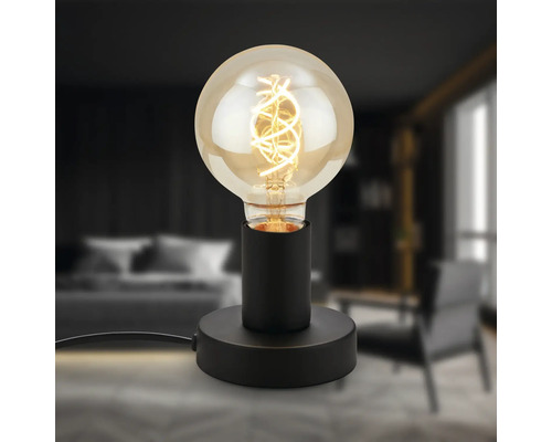Dekorative Tischleuchte mit Glühbirne auf schwarzem Sockel