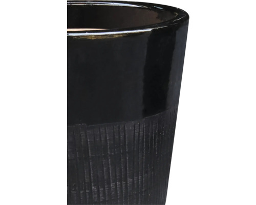 Gros plan d'un pot de fleurs noir avec une texture rainurée.