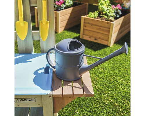 Arrosoir sur une table de jardin avec outils de jardinage et jardinières