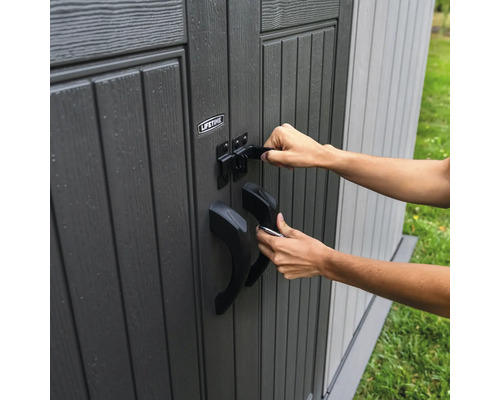 Une personne ferme une boîte de rangement pour outils de jardin avec un loquet